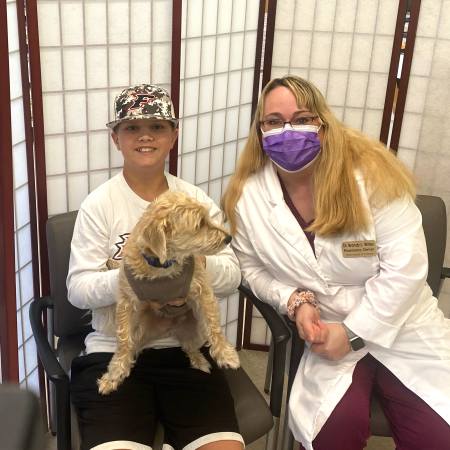 Pharmacist Brandy Willey (right) pictured with a patient holding Charlie, Willey Pharmacy’s emotional support animal.