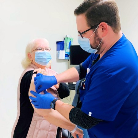 Pharmacist James Cody Sandusky vaccinating his grandmother at Harrisburg Medical Center in Illinois.