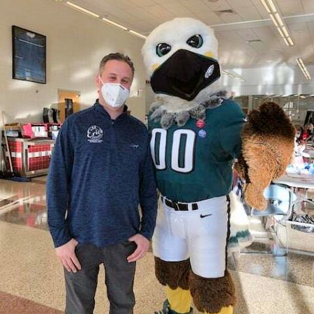 Certified pharmacy technician Marc Ost and the Philadelphia Eagles mascot, Swoop, at Lower Merion High School in Ardmore, Pennsylvania, for a vaccine clinic.