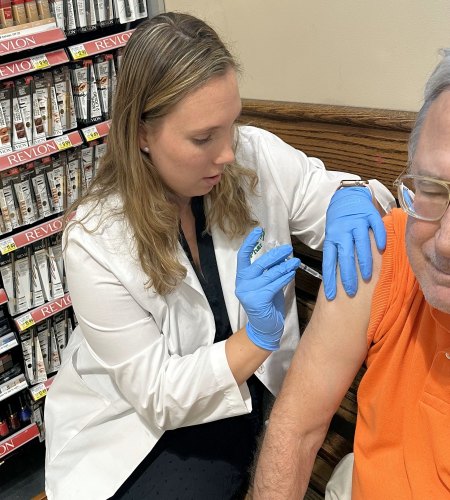 Pharmacist Adrienne Stute administers a COVID-19 vaccine to an older patient at the Harris Teeter Pharmacy in Pinehurst, North Carolina, where more than half the population is over age 65 and more vulnerable to severe illness from the virus.