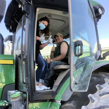 Pharmacist Casey Villhauer (left) after administering a vaccine to a farmer in northwest Iowa who was hauling grain in October 2021.
