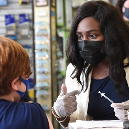 Pharmacist Chichi Momah talks with a patient during a pediatric vaccine clinic at Springfield Pharmacy in Delaware County, Pennsylvania.