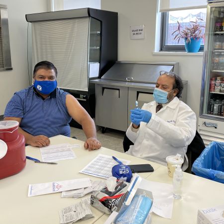 Pharmacist Dipan Ray (right) preparing to administer a COVID-19 vaccine to a patient at Touro University in New York City.
