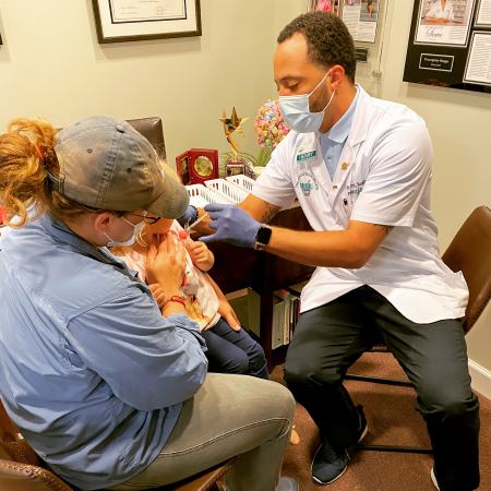 Pharmacist Henry Ranger vaccinates a pediatric patient at The Prescription Shoppe in Williamsburg, Virginia.