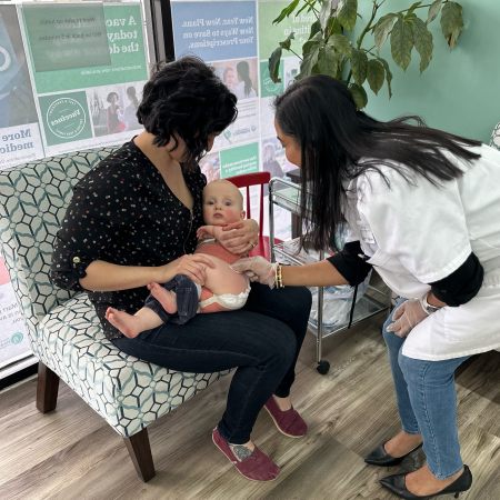 Pharmacist Hetal Patel (right) engages with an infant prior to administering a COVID-19 vaccine at Lebanon Family Pharmacy in Lebanon, Tennessee.