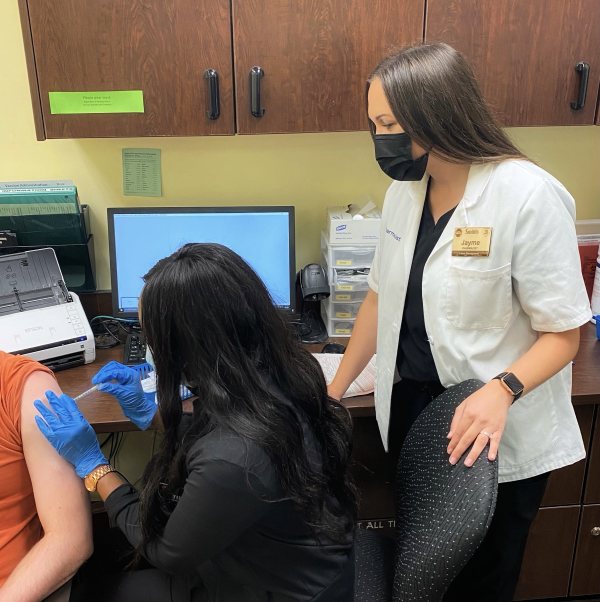 Pharmacist Jayme Garcia supervises a pharmacy technician administering a COVID-19 vaccine in Salt Lake City, Utah.