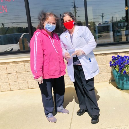 Pharmacist Jennifer Shannon (right) stands with her mother, who assisted with vaccination efforts, in front of Lily’s Pharmacy in Johns Creek, Georgia.