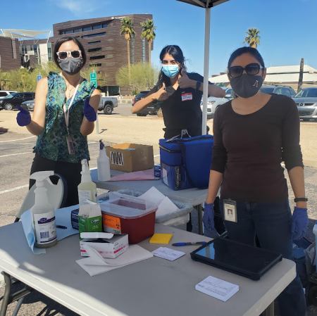 Pharmacist and Assistant Professor Nicole Henry (left) of the R. Ken Coit College of Pharmacy, Associate Professor Leila Barraza (right) of the Mel and Enid Zuckerman College of Public Health, and a medical student (center) at a COVID-19 vaccine clinic in central Phoenix.