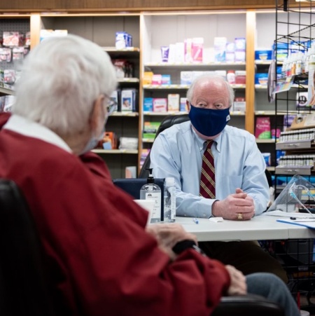 Pharmacist Ralph Sorrell counsels a patient prior to administering a COVID-19 vaccine at Ritch’s Pharmacy in Mountain Brook, Alabama.