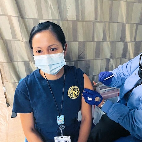 Pharmacist Reasol Chino receives the COVID-19 vaccine in Tuba City, Arizona.