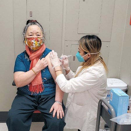 Pharmacist Zoua Yang vaccinates a patient against COVID-19 at a CVS Pharmacy in Schofield, Wisconsin.
