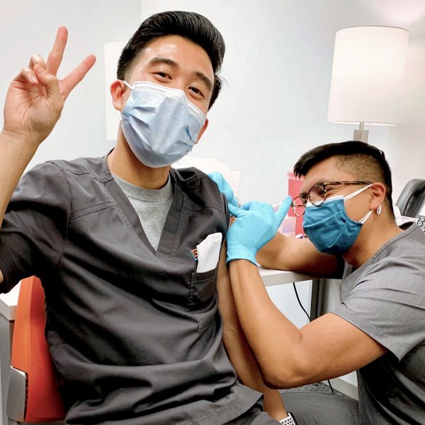 Student pharmacist Mario Gutierrez vaccinates a frontline Legacy Community Health staff worker in Houston, Texas.