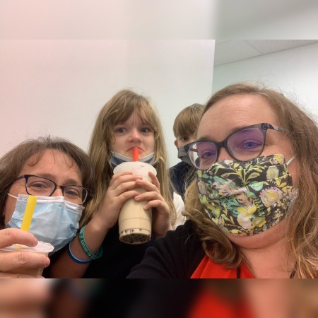 Seven-year-old patient (center), accompanied by her brother and mother (right), brought bubble tea to pharmacist Trish Klatt (left) after receiving a COVID-19 vaccine at the Pitt Vaccination and Health Connection Hub.
