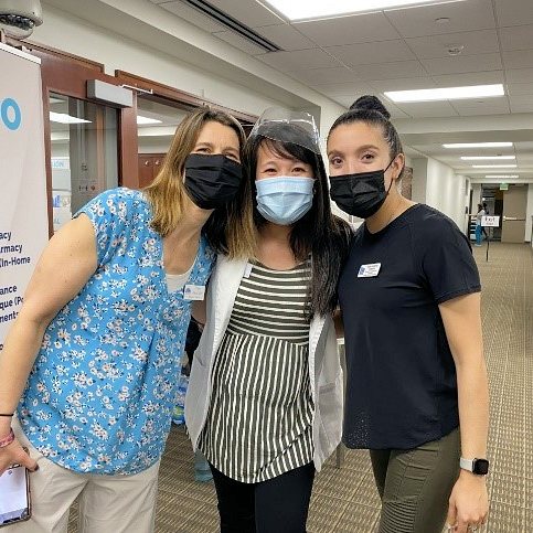 Pharmacist Pamela Wiltfang (center) coordinated with community volunteers Ellen Alexander (left) and Paola Jaramillo Guayara (right) to set up local COVID-19 vaccine clinics for underserved and non—English–speaking people in Coralville, Iowa.